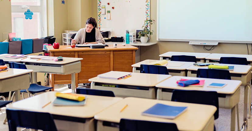 teacher at desk in classroom